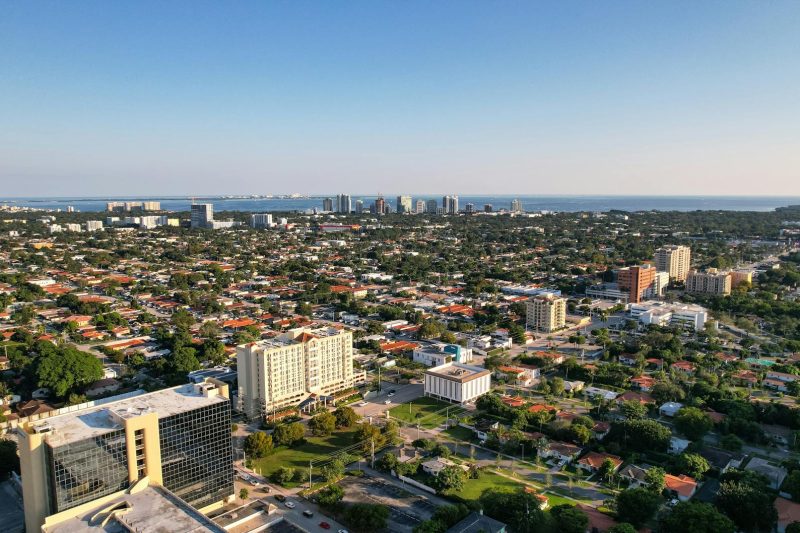 Aerial view of Miami’s skyline with modern skyscrapers and the ocean in the background.