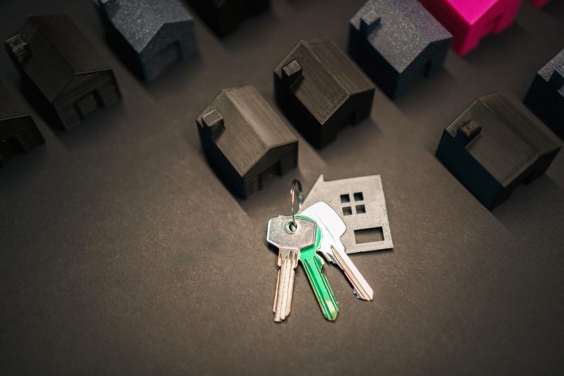Blog 10 Miniature house models arranged with various keys, representing real estate investment and the housing market.