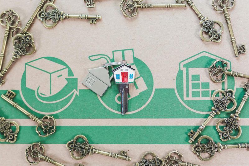 Vintage keys arranged with a modern house key, representing real estate and home ownership.