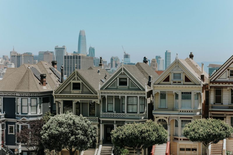 Blog 11 Colorful Victorian houses in San Francisco with a city skyline backdrop.