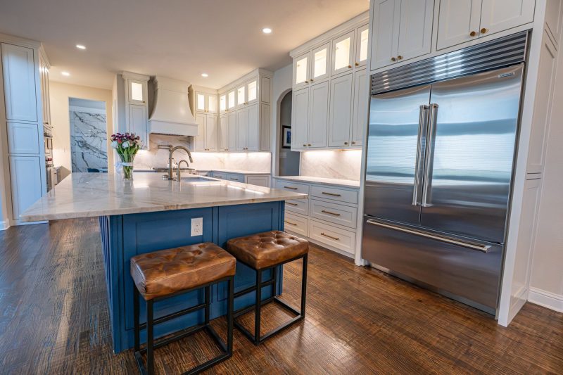 Home 14 Spacious Colleyville kitchen with marble countertops, a center island, stainless steel appliances, and sleek cabinetry.