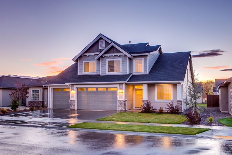 Home 11 Elegant suburban home with a modern architectural design, illuminated by warm sunset light, featuring a curved driveway.